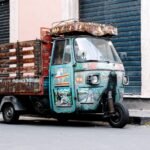 blue and red car parked beside blue and white wall